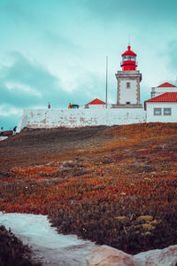 Lighthouse by sea against sky