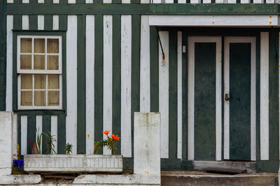 Typical white and green houses srtipes in costa nova - aveiro against sky