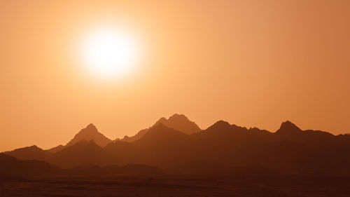 Scenic view of silhouette mountains against sky during sunset