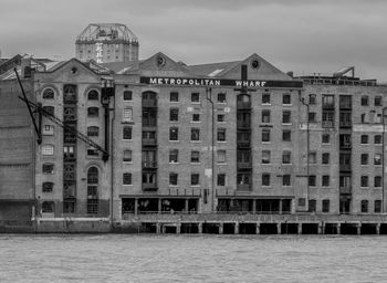 Built structure by sea against sky in city