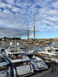 Boats moored at harbor against sky