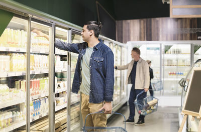 Customers shopping at refrigerated section in supermarket