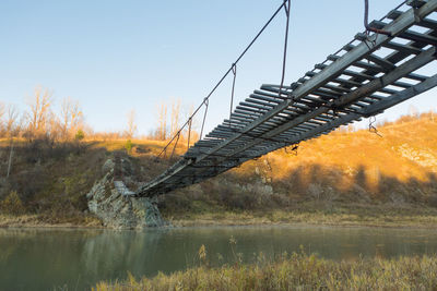 Bridge over calm lake against clear sky