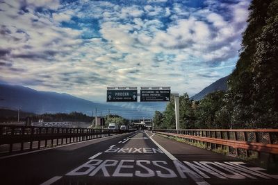 View of road sign against cloudy sky