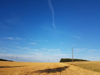 Scenic view of field against blue sky