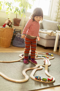 Full length of girl standing on train set at home
