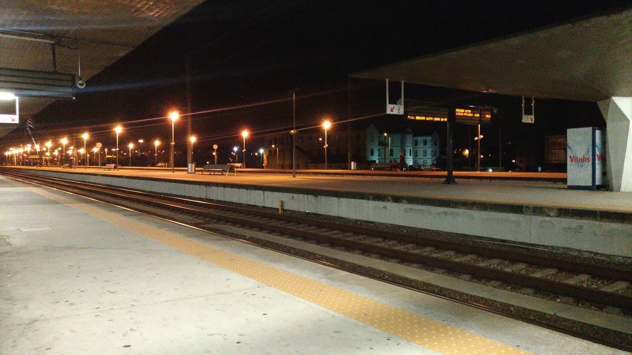 VIEW OF RAILROAD STATION PLATFORM AT NIGHT