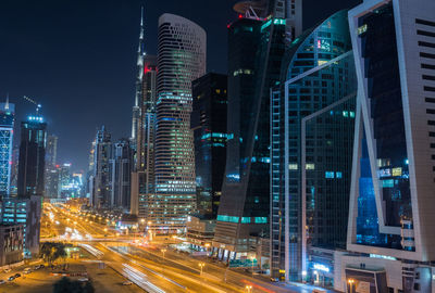 Illuminated buildings in city against sky at night