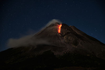 Scenic view of volcanic mountain against sky at night