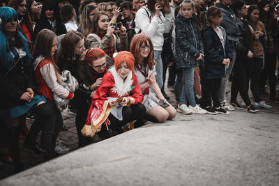 People sitting on street in city