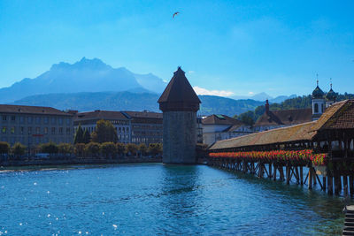 Bridge over river and buildings against blue sky