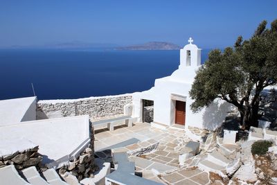 Buildings by sea against sky