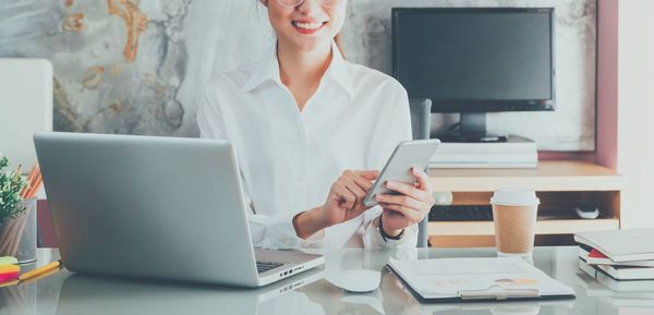 Midsection of woman using laptop on table