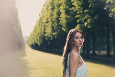 Portrait of young woman standing on field