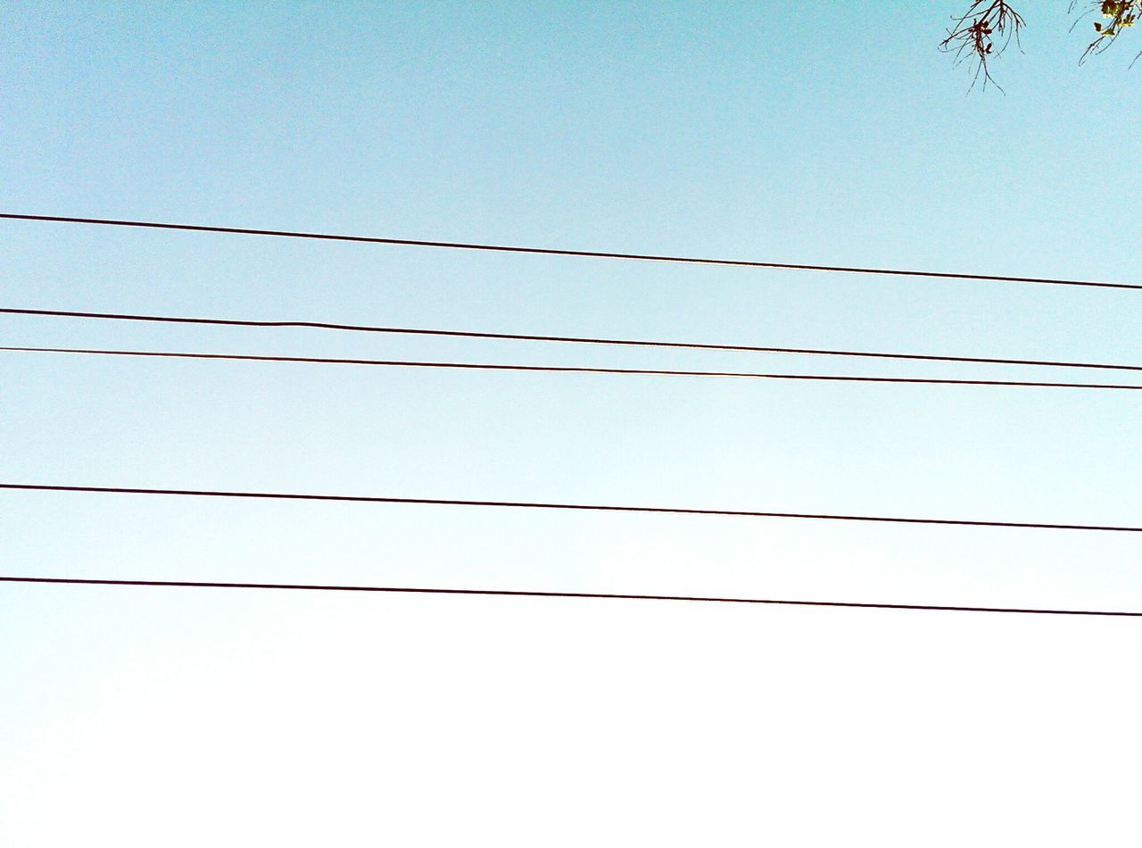 clear sky, power line, copy space, cable, low angle view, connection, blue, power supply, electricity, electricity pylon, wire, fuel and power generation, outdoors, no people, power cable, nature, day, rope, barbed wire, technology