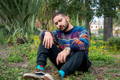 Portrait of young man sitting on field