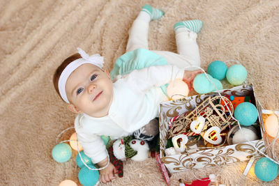 High angle portrait of cute baby lying on sofa at home