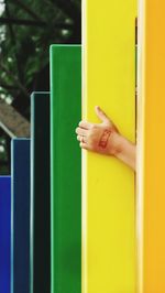 Cropped hand of woman amidst multi colored metal