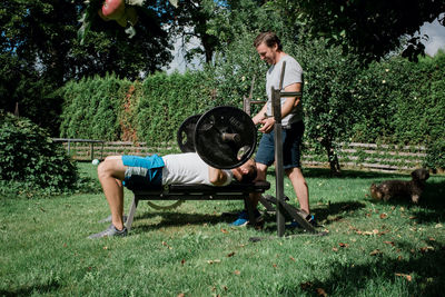 Two men working out together at home in the garden gym