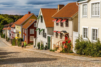 Street by houses against sky