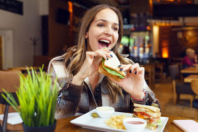 Portrait of a smiling young woman eating food