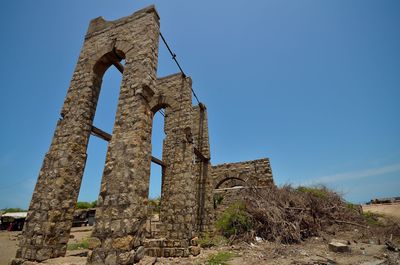 Low angle view of old ruins against blue sky