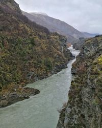 Scenic view of river amidst mountains against sky