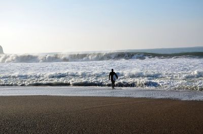 Man on beach against clear sky