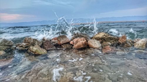 View of rocks in sea against sky