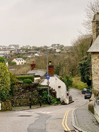 Road by buildings against sky in city