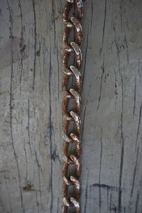 Close-up of chain on table against wall