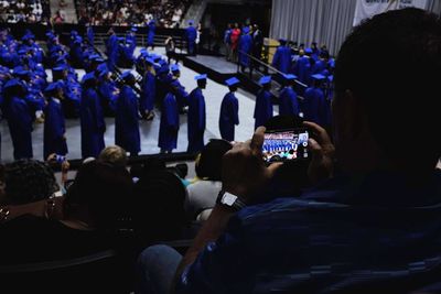 Rear view of people photographing at music concert