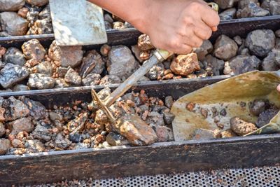 Close-up of person preparing food on barbecue grill