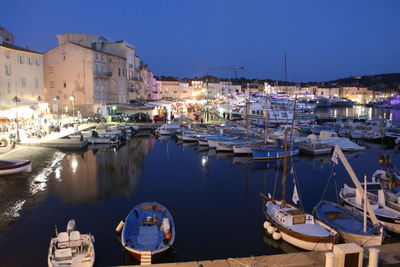 Boats moored at harbor in city