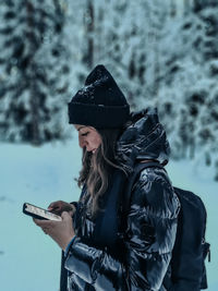 Portrait of young woman standing in forest