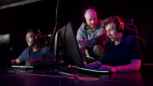 Man using computer by friends in darkroom