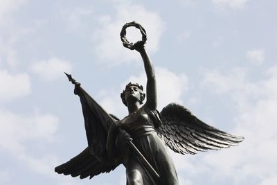 Low angle view of angel statue against sky