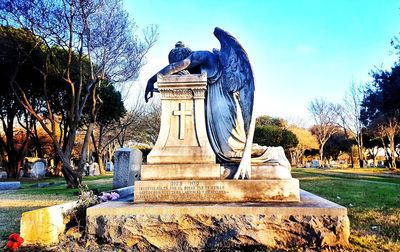 Statue in park against sky