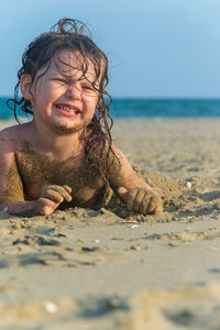 Cute girl playing on sand at beach