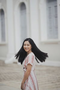 Portrait of a smiling young woman standing outdoors