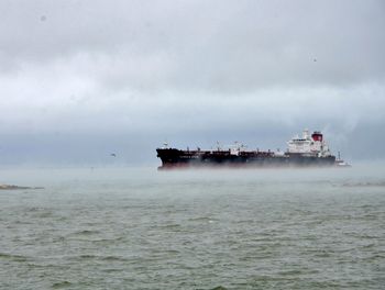 Ship sailing on sea against sky