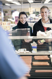 Young couple buying food at gas station