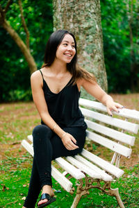 Smiling young woman sitting on bench