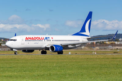 Airplane on airport runway against sky