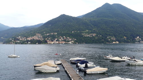 Boats moored in lake against sky