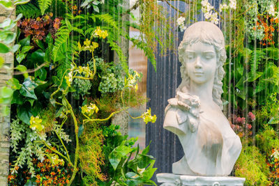 Statue of buddha against plants