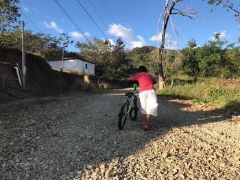 Man walking on road against sky