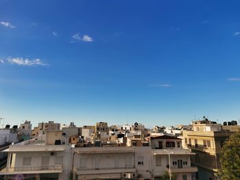 High angle view of buildings against blue sky