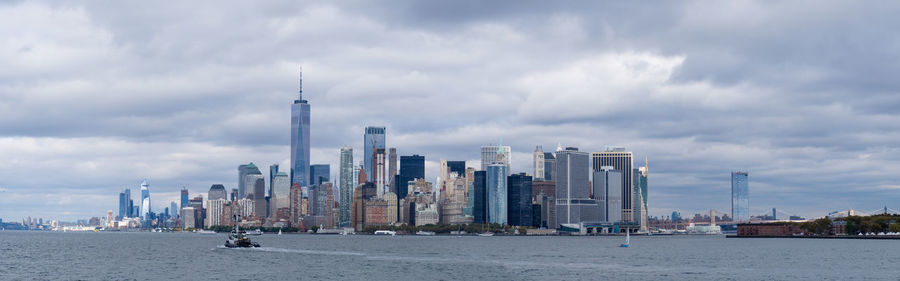 Panoramic view of buildings against cloudy sky