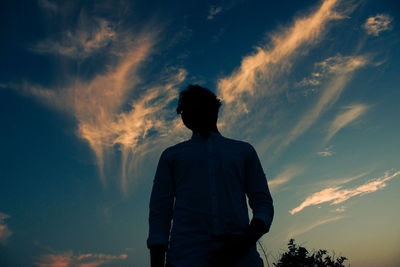 Rear view of silhouette man standing against sky during sunset